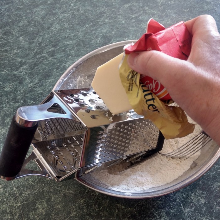 Grating the frozen butter.